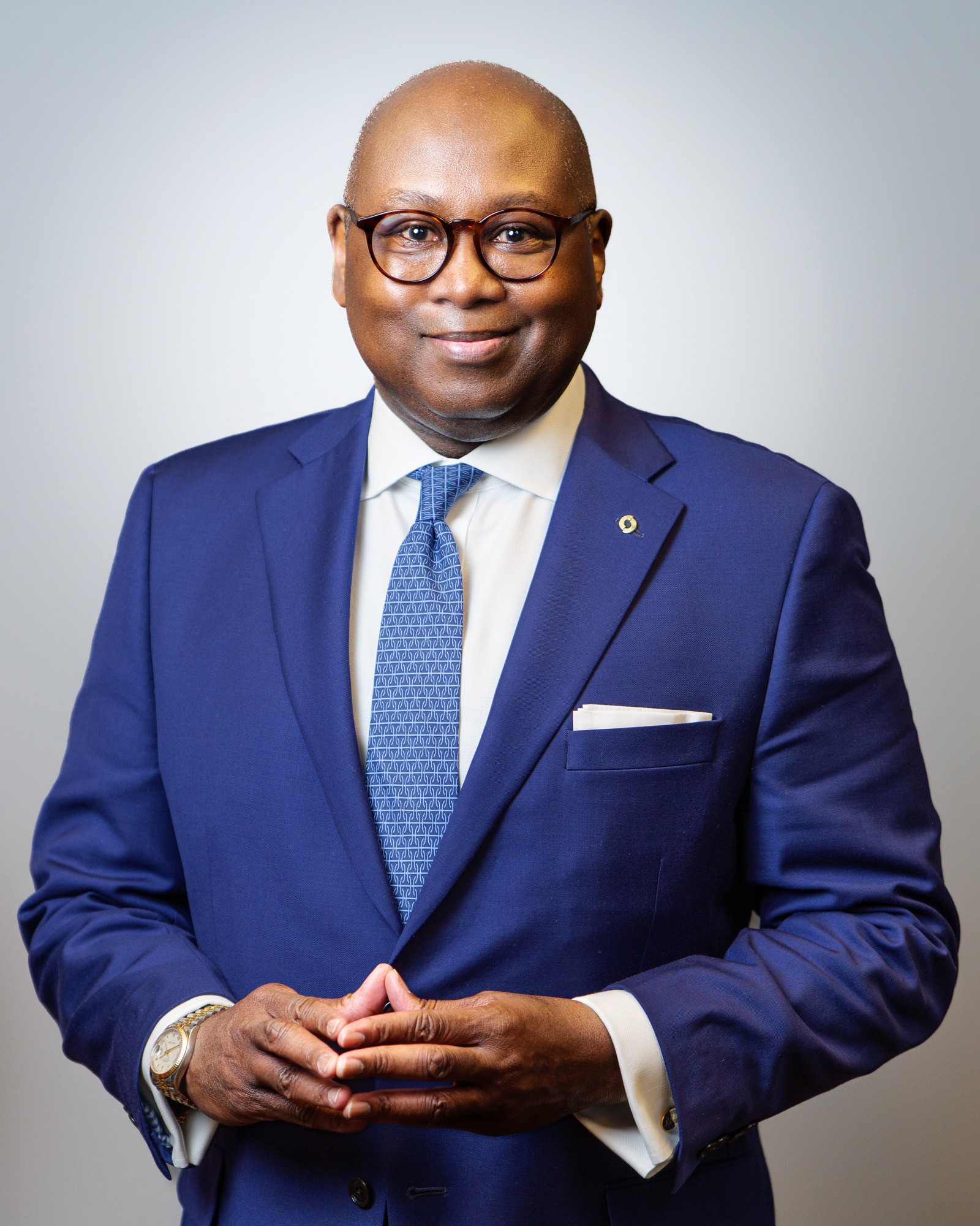 Portrait of a man with glasses wearing a gray shirt.